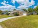 Exterior view of a single-story home with attached garage and lush green lawn at 1422 Missouri Ave, St Cloud, FL 34769