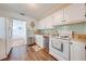 A kitchen featuring white cabinets, wood-look flooring, a refrigerator and a stainless steel dishwasher at 1422 Missouri Ave, St Cloud, FL 34769