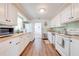 A kitchen featuring white cabinets, wood-look flooring, a refrigerator and a stainless steel dishwasher at 1422 Missouri Ave, St Cloud, FL 34769