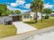 This single-story home includes an attached carport, lush greenery, and mature palm trees at 1422 Missouri Ave, St Cloud, FL 34769