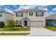 Two-story home featuring a two-car garage, manicured lawn, and neutral-toned facade at 164 Emanuelle Dr, Winter Haven, FL 33884