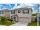 Two-story home featuring a two-car garage, manicured lawn, and neutral-toned facade at 164 Emanuelle Dr, Winter Haven, FL 33884