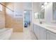 Bathroom features tiled shower-tub combo, tiled floor and white vanity at 1941 Mathis Rd, St Cloud, FL 34771