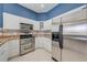 Bright kitchen featuring stainless steel appliances, sleek white cabinetry, and granite counter tops at 1941 Mathis Rd, St Cloud, FL 34771