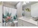 Bright bathroom featuring a floral shower curtain and a white vanity with a quartz countertop at 1948 Molise Dr, Kissimmee, FL 34759