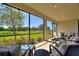 Comfortable screened-in lanai with a view of the lush green lawn and mature trees at 1948 Molise Dr, Kissimmee, FL 34759