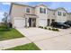 Charming townhomes featuring attached garages and landscaping at 208 Feltrim Reserve Blvd, Davenport, FL 33837