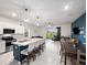 Open-concept floor plan with modern kitchen flowing into the living and dining areas at 208 Feltrim Reserve Blvd, Davenport, FL 33837