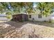 Backyard with a screened porch, foliage, and a building with grey windows on a sunny day at 218 Cranbrook Dr, Kissimmee, FL 34758