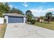 Home exterior featuring a gray painted garage, a long driveway and well-manicured lawn at 218 Cranbrook Dr, Kissimmee, FL 34758
