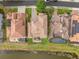 An overhead shot of three houses including a backyard patio and yard going up to the water at 2234 Callaway Ct, Davenport, FL 33837