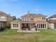 An outdoor dining area and outdoor kitchen are on the patio behind this two-story home at 2234 Callaway Ct, Davenport, FL 33837