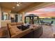 Covered patio with brick pavers, featuring a comfortable seating arrangement, outdoor kitchen, and expansive backyard views at 2234 Callaway Ct, Davenport, FL 33837
