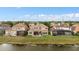 The rear of this elegant, tan, two-story home features a large lawn and dining area at 2234 Callaway Ct, Davenport, FL 33837