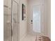 Contemporary bathroom with glass-enclosed shower, tile accents, and a door to the backyard area at 2234 Callaway Ct, Davenport, FL 33837