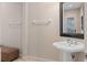 Well-lit powder room features a pedestal sink, decorative mirror, and neutral tones for a clean, classic look at 2234 Callaway Ct, Davenport, FL 33837