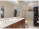 Bright bathroom featuring a double sink vanity with marble countertops, shower and tub combo, and a large mirror at 2234 Callaway Ct, Davenport, FL 33837
