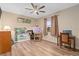Bedroom with light wood floors, a ceiling fan, window, an easel with painting, and various other paintings around the room at 2234 Callaway Ct, Davenport, FL 33837