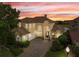 Stunning home showcases tile roof, lush landscaping, brick driveway, and ample curb appeal with a picturesque sunset backdrop at 2234 Callaway Ct, Davenport, FL 33837