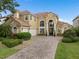 Elegant two-story home featuring a clay tile roof, arched windows, and a well-manicured front yard at 2234 Callaway Ct, Davenport, FL 33837