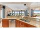 Open-concept kitchen and living space features granite counters, wood cabinets, and backyard views at 2234 Callaway Ct, Davenport, FL 33837