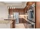 A modern kitchen with stainless steel appliances, wooden cabinets, and granite countertops at 2234 Callaway Ct, Davenport, FL 33837
