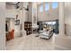 This beautiful living room boasts soaring ceilings, tiled floors, a fireplace, and large windows with backyard views at 2234 Callaway Ct, Davenport, FL 33837