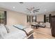 Large primary bedroom suite featuring wood floors, ceiling fan, two windows, a bed, and a seating area with sofa at 2234 Callaway Ct, Davenport, FL 33837
