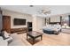 Large primary bedroom suite featuring wood floors, ceiling fan, three windows, a bed, TV, and seating area at 2234 Callaway Ct, Davenport, FL 33837