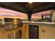 Fully equipped outdoor kitchen with stainless steel grill, refrigerator, and counter seating with lake views at 2234 Callaway Ct, Davenport, FL 33837