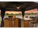 Covered outdoor kitchen featuring a stainless steel grill, bar seating, and stunning lake views at 2234 Callaway Ct, Davenport, FL 33837