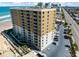Aerial view of the high-rise building, beach, and street featuring balconies and parking at 2403 S Atlantic Ave # 501, Daytona Beach Shores, FL 32118