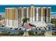 Full, direct aerial view of the building featuring parking, landscaping and ocean views at 2403 S Atlantic Ave # 501, Daytona Beach Shores, FL 32118