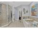 Bathroom featuring glass enclosed shower, soaking tub with decor and beach themed art at 2403 S Atlantic Ave # 501, Daytona Beach Shores, FL 32118