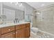 Well-lit bathroom featuring a vanity with sink, toilet, and glass-enclosed shower with tiled walls at 2403 S Atlantic Ave # 501, Daytona Beach Shores, FL 32118