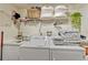 Well-organized laundry room features a sink, washer, dryer, wire shelving and decorative storage baskets at 2403 S Atlantic Ave # 501, Daytona Beach Shores, FL 32118