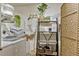 Bright laundry room features a shelving unit with a plant, baskets and decorative items by the machines at 2403 S Atlantic Ave # 501, Daytona Beach Shores, FL 32118