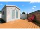 Cozy backyard features a shed and a red Adirondack chair on the wooden deck at 2506 Bali Cir, Kissimmee, FL 34741