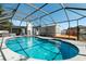 Inviting in-ground pool enclosed with a screened cage, with a deck and lush landscaping at 2506 Bali Cir, Kissimmee, FL 34741