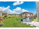 Manicured backyard with lush green lawn, a gazebo with outdoor seating, and a decorative fence overlooking a serene lake at 2874 Turnstone Run, Harmony, FL 34773