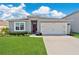Charming single-story home featuring a two-car garage, well-manicured lawn, and inviting front entrance at 2874 Turnstone Run, Harmony, FL 34773
