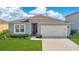 Charming single-story home with a manicured lawn, a red front door, and an attached two-car garage at 2874 Turnstone Run, Harmony, FL 34773