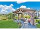 Charming gazebo with comfortable seating, draped curtains, and decorative landscaping in a serene backyard setting at 2874 Turnstone Run, Harmony, FL 34773