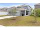 An outdoor view shows a well-maintained lawn and backyard attached to a home with modern architectural style at 2877 Fitness St, Clermont, FL 34714