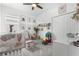 Bedroom with gray carpeting, a ceiling fan, several toys, and baby jungle animal artwork at 2877 Fitness St, Clermont, FL 34714