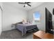 Cozy bedroom with gray carpeting, a ceiling fan, and large window at 2877 Fitness St, Clermont, FL 34714