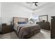 Main bedroom featuring a ceiling fan, large bed with storage, and ensuite bathroom at 2877 Fitness St, Clermont, FL 34714