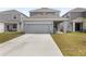 Exterior view showcases the home's backyard, driveway, garage, and architectural details on a sunny day at 2877 Fitness St, Clermont, FL 34714