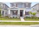 Charming two-story home featuring a covered porch with stone accents and a well-maintained lawn at 2877 Fitness St, Clermont, FL 34714