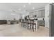 Open-concept kitchen and dining area with gray cabinets, an island with seating, and tile flooring at 2877 Fitness St, Clermont, FL 34714